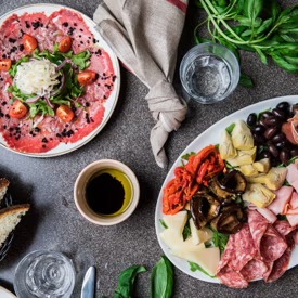 Italian antipasto spread with salami, olives and beef carpaccio
