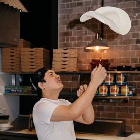 Pizza chef hand-tossing dough at The Grumpy Italian — pizza Leichhardt